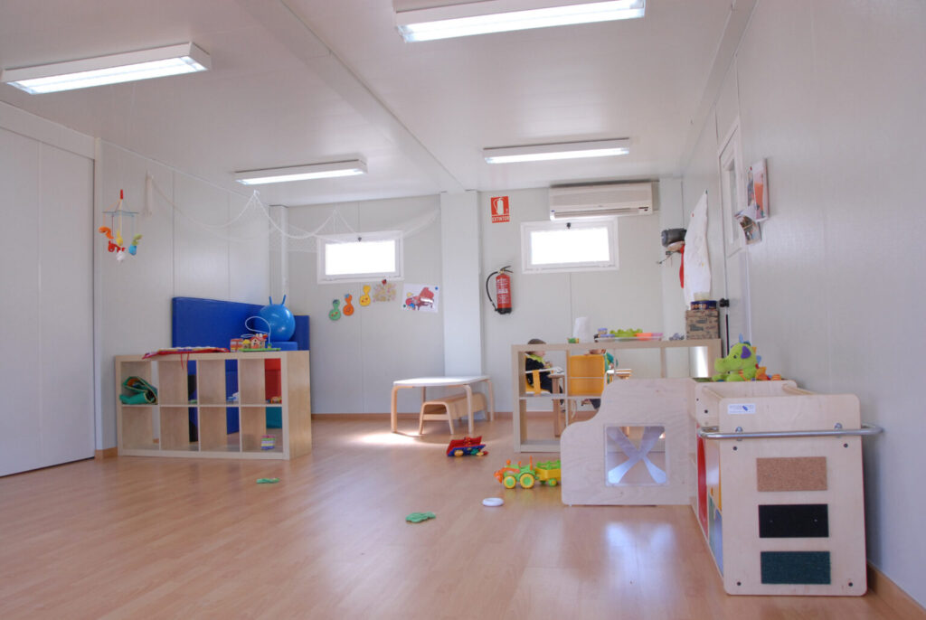 Aula infantil con juguetes y mobiliario.