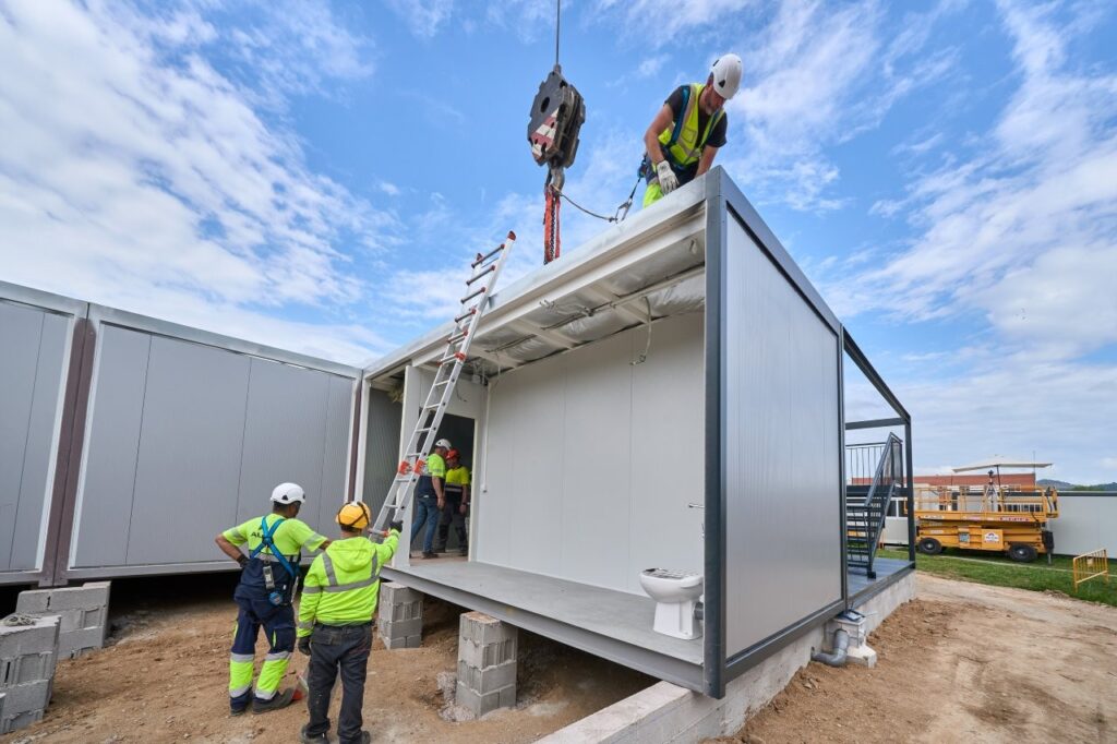 Operarios trabajando en la colocación de módulos prefabricados en la obra